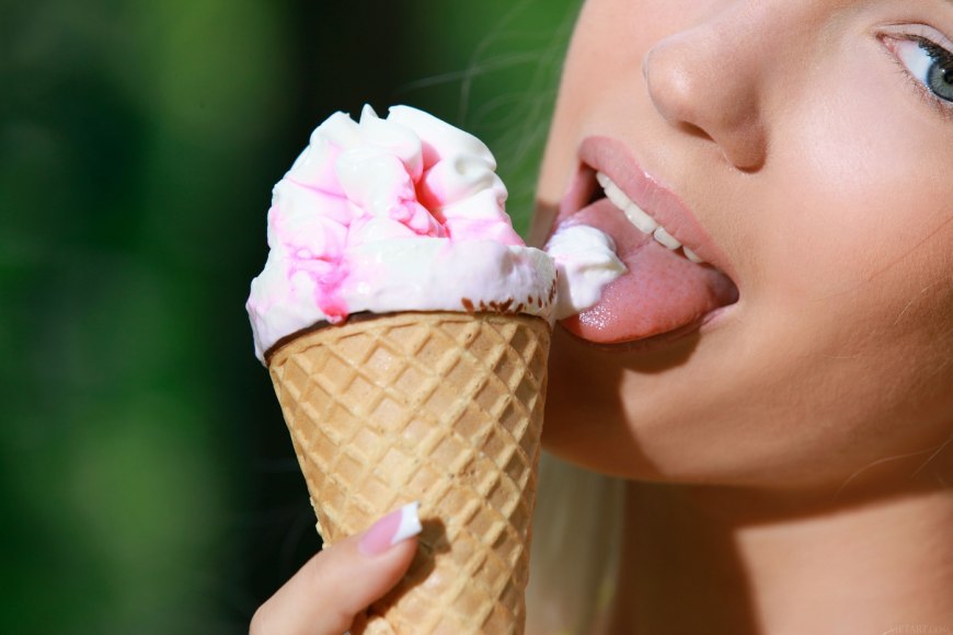 Девушка ест мороженое секси на белом фоне