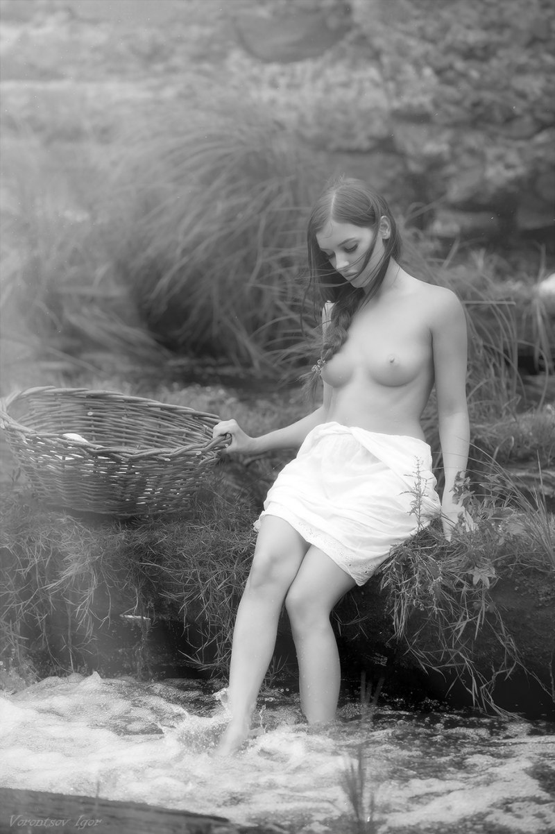 Голая женщина стирает белье на речке