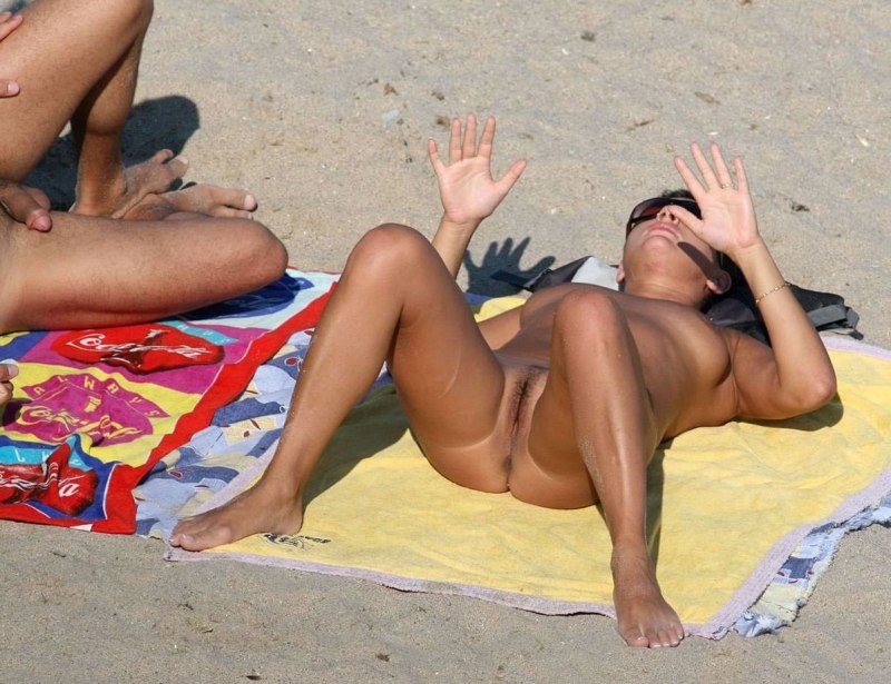 Загорает на пляже раздвинув ноги