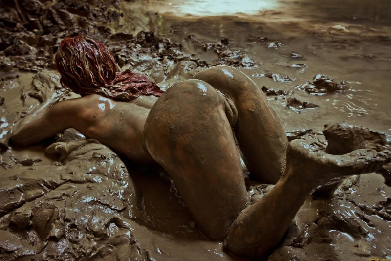 Голая женщина купается в луже