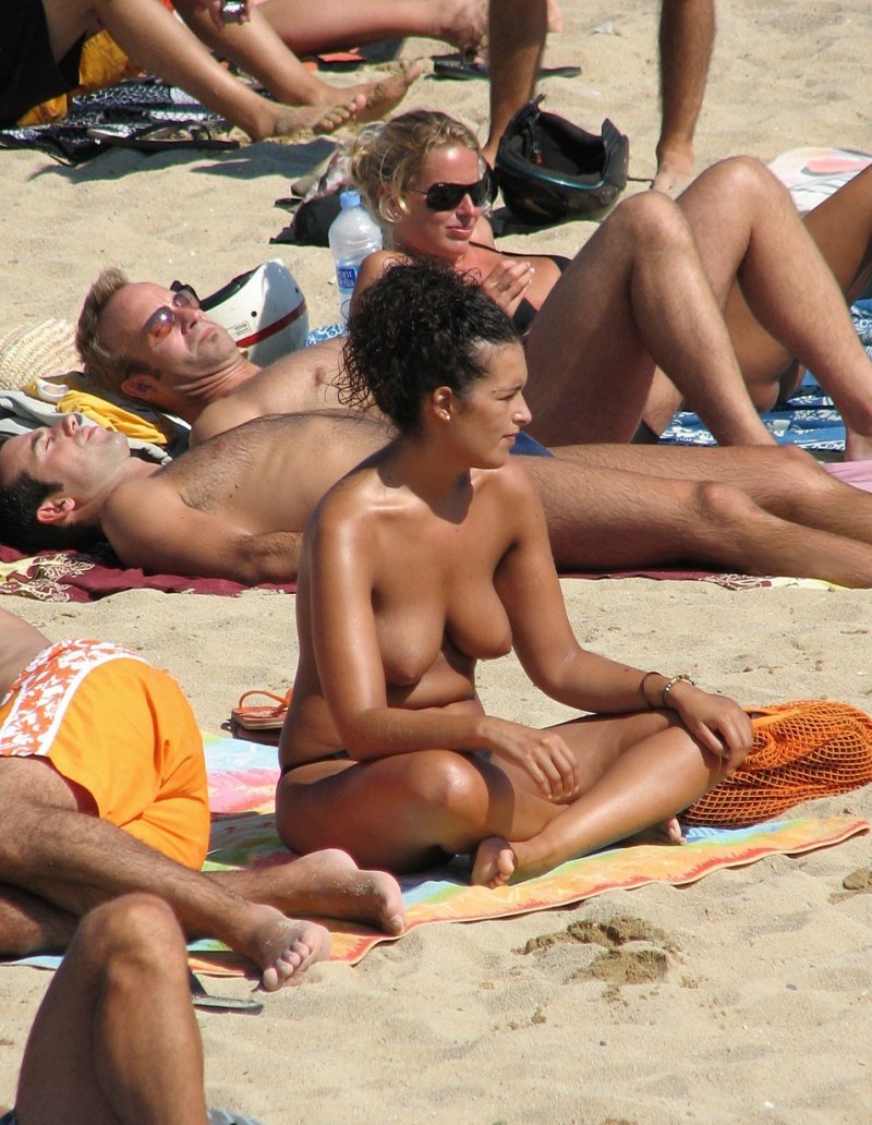 Наблюдатель смотрит на нудистку на пляже